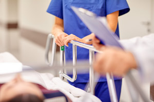 A female Nurse and a Male Physician are talking next to a female patients stretcher before surgery.