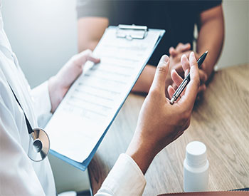 Doctors and patients sit and talk. At the table near the window in the hospital.